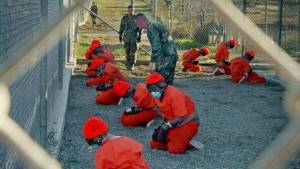 prisoners in red uniforms and shackles at Guantanamo Bay prison