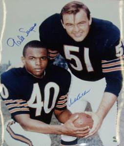 Gale Sayers and Dick Butkus pose, holding a football