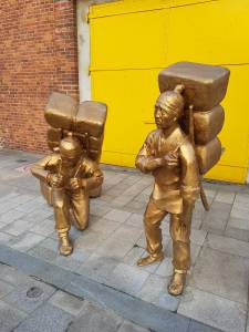 statues of Korean "coolies" with loads on their backs