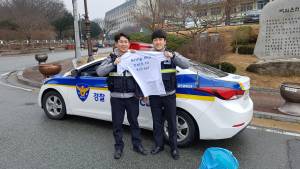 Pyeonghae policemen holding Bring Jikji Back to Korea T-shirt