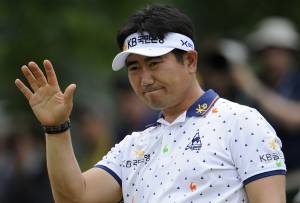 Yang Yong-eun waves to fans after making golf shot