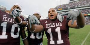 Texas A&M players do Horns down