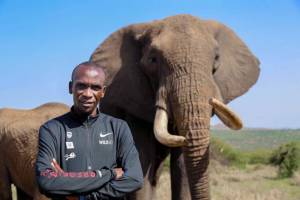 Eliud Kipchoge standing in front of an elephant in Kenya